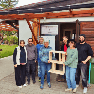 Familien-Schreiner-Workshop Bücherregal Familie hält ihr selbst gebautes Holz-Bücherregal vor der Schreinerei Wabro nach dem Familien-Schreiner-Workshop.